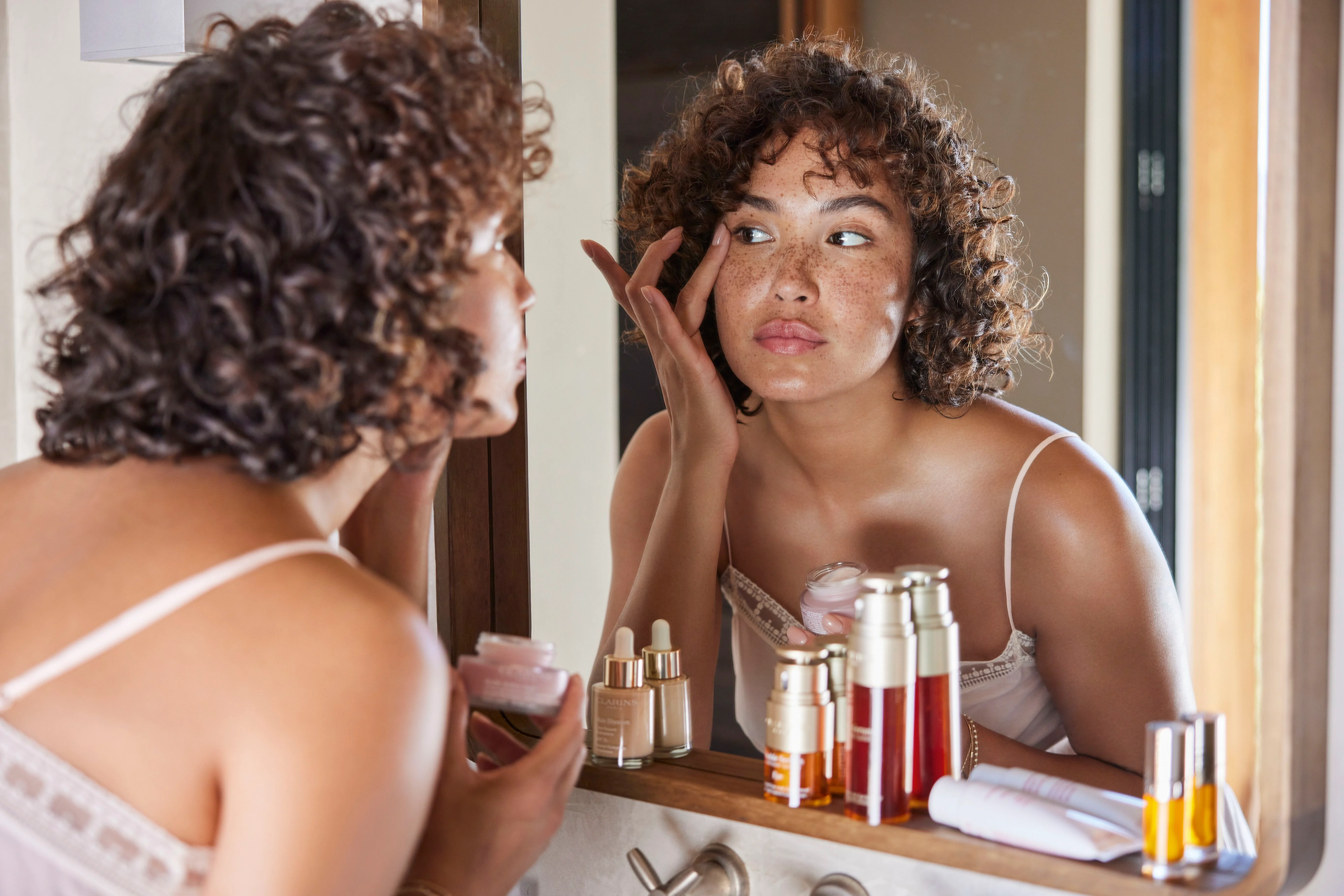 Woman in a mirror treating yourself with Vitalise products.