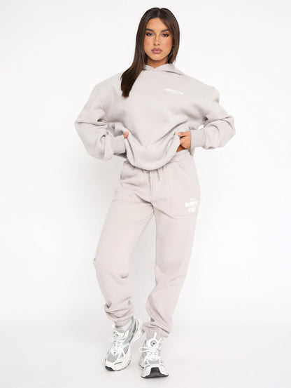 A sleek and modern Whitefox Autumn Kit, featuring a stylish, tailored tracksuit in classic white. The kit is crafted from premium, breathable fabric (65% cotton, 35% polyester), designed for maximum comfort during both active days and relaxed weekends. It includes thoughtful details like a bold logo, snug cuffs, zippered pockets, and an adjustable waistband for a perfect fit. The versatile design easily transitions from casual to sporty, making it a wardrobe staple for all body types.